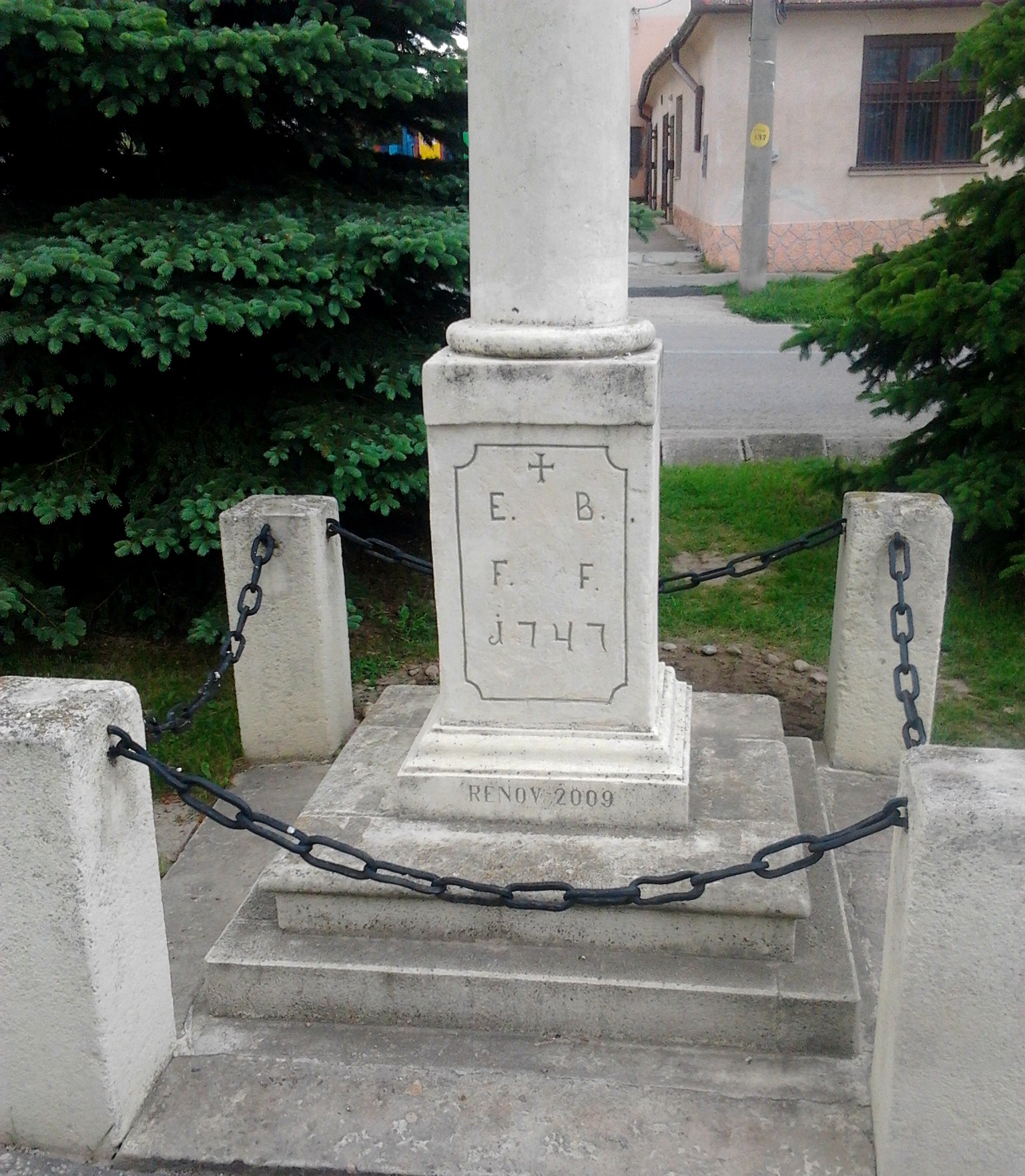 Podstavec kamenného kríža pred kostolom s letopočtom 1747
